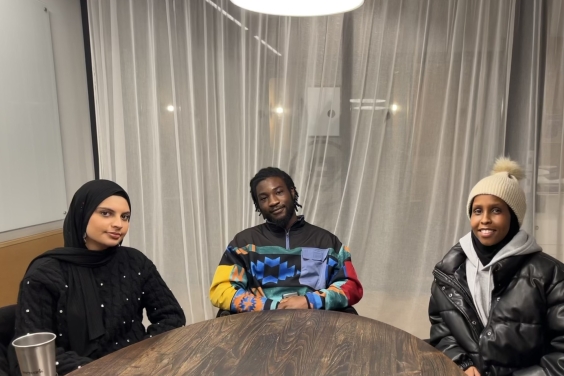 Three young people sitting at a table. A team of Podcasters in Manchester.